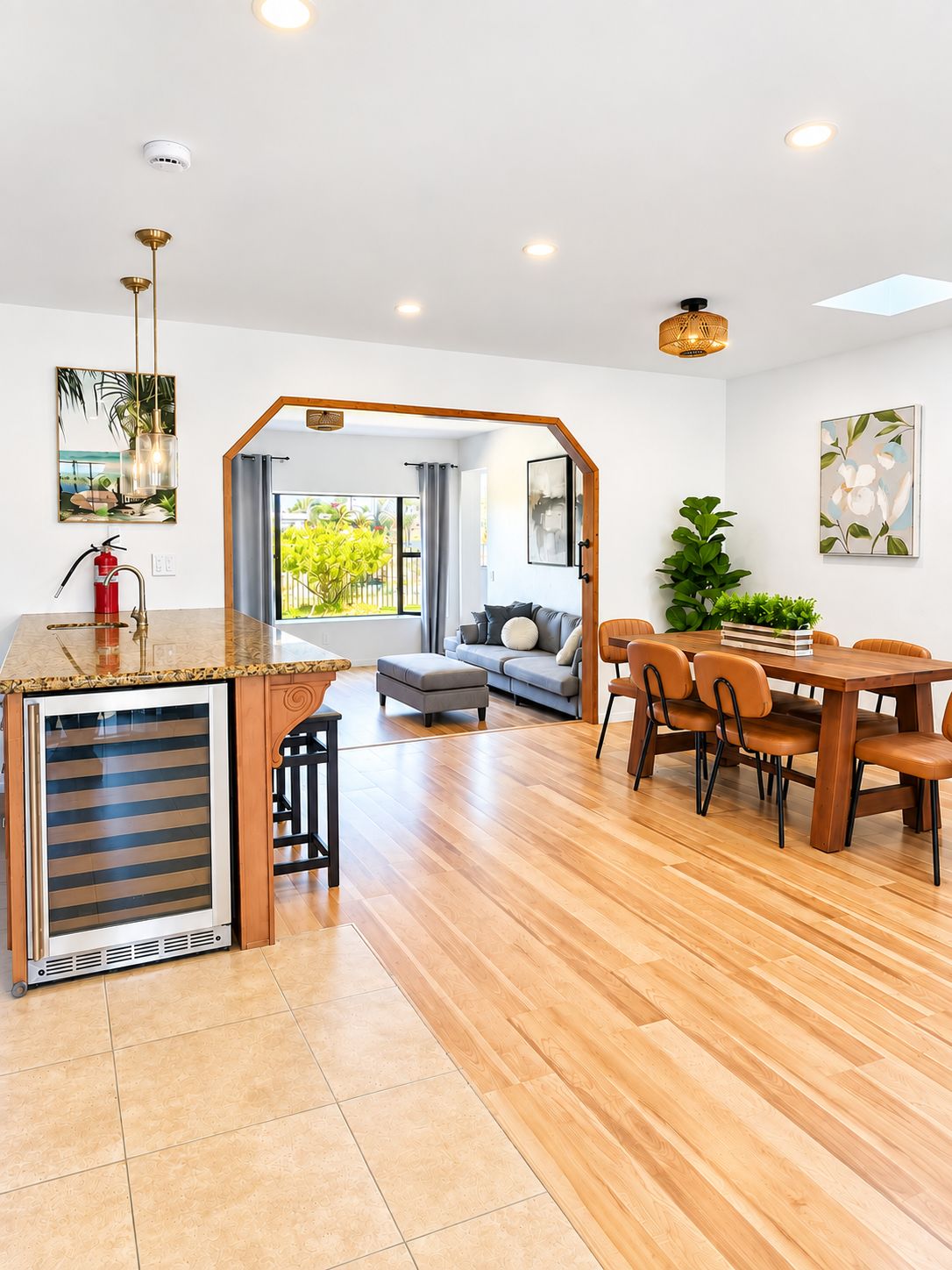 A modern living space with a kitchen area, dining table, and a sofa set.