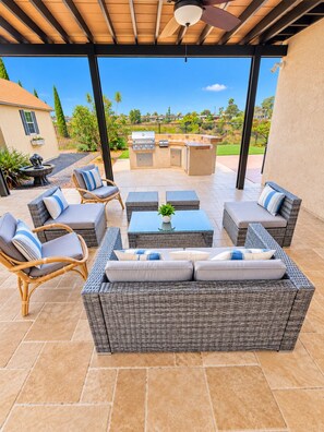 An outdoor patio with wicker furniture, a grill, and a view of the neighborhood. - Canyon View Home, 10 Min to Zoo, Beach & Downtown (San Diego)