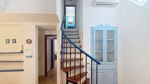 Eine Treppe mit hölzernen Stufen und blauen Geländern, die zu einer Zwischenebene führt.