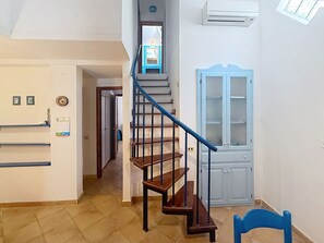 Eine Treppe mit hölzernen Stufen und blauen Geländern, die zu einer Zwischenebene führt.