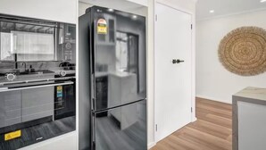 Une cuisine moderne avec un réfrigérateur noir, un four à micro-ondes et une cuisinière.