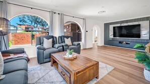 Un salon moderne avec un ensemble de canapés, une table basse et un téléviseur à écran plat.