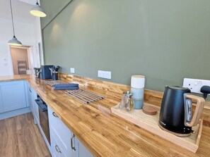 A kitchen with a wooden countertop, a kettle, and a coffee maker. - 3 bedroom accommodation in Tavistock (Tavistock)