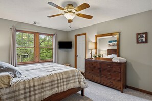 A bedroom with a bed, dresser, ceiling fan, and a large window. - Group-Friendly Stay + Deck Dining + BBQ | Near Ski + Waterparks | Aspen Hollow (Tannersville)