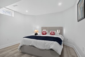 A bedroom with a bed, a bedside lamp, and a window. - Luxury 2BR Basement near Wonderland/Vaughan, Wi-Fi (Vaughan)