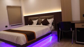 Une chambre d’hôtel avec un lit, un bureau et une chaise.