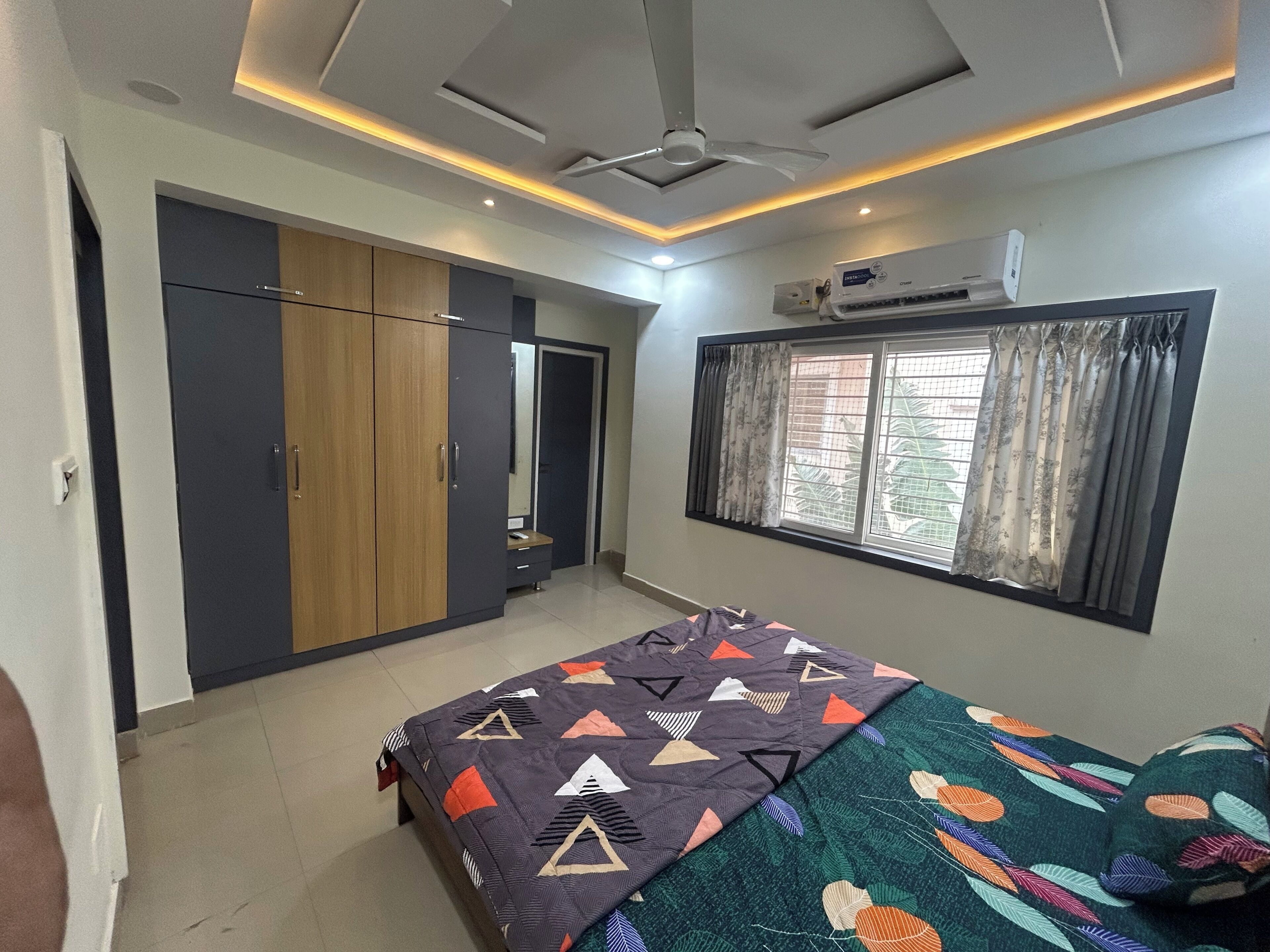 Une chambre à coucher avec un lit, une armoire et une fenêtre avec des rideaux.