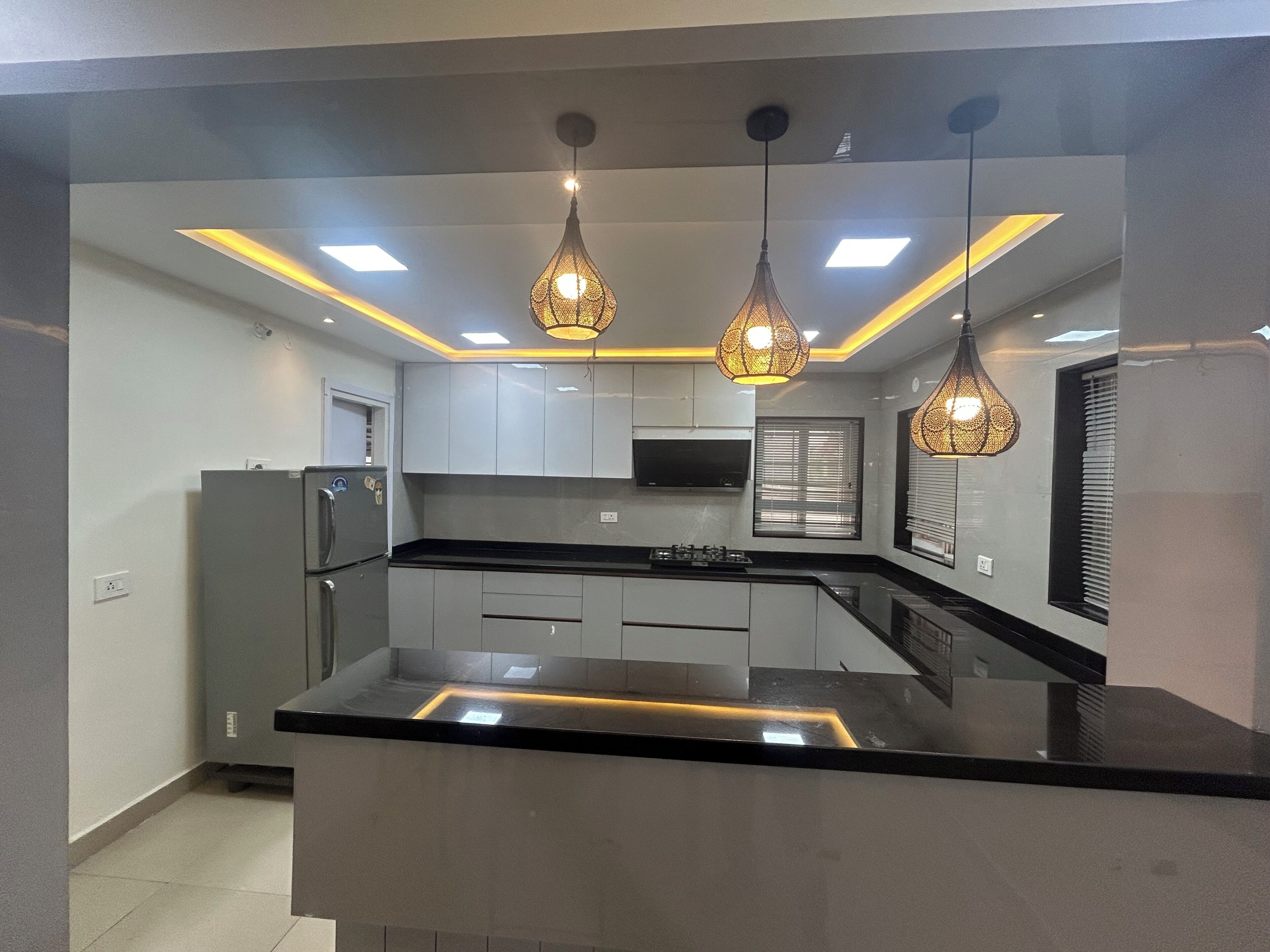 A modern kitchen with a central island, pendant lighting, and built-in appliances.