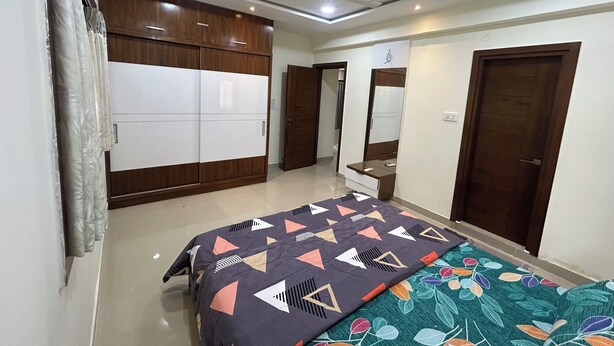 Quarto com cama, guarda-roupa, espelho e ventoinha no teto.