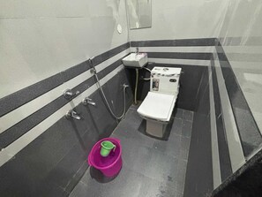 A small, compact bathroom with a toilet, sink, and shower. - Krapalu Hari Dham (Vrindavan)