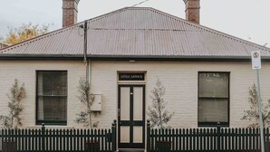 Un bâtiment avec une enseigne portant l’inscription « Little Arthur » au-dessus de l’entrée, une clôture en piquets et un toit en métal.