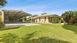 A two-story building with a covered parking area and a well-maintained lawn. - 5 Zircon Street - Rainbow Beach (Rainbow Beach)