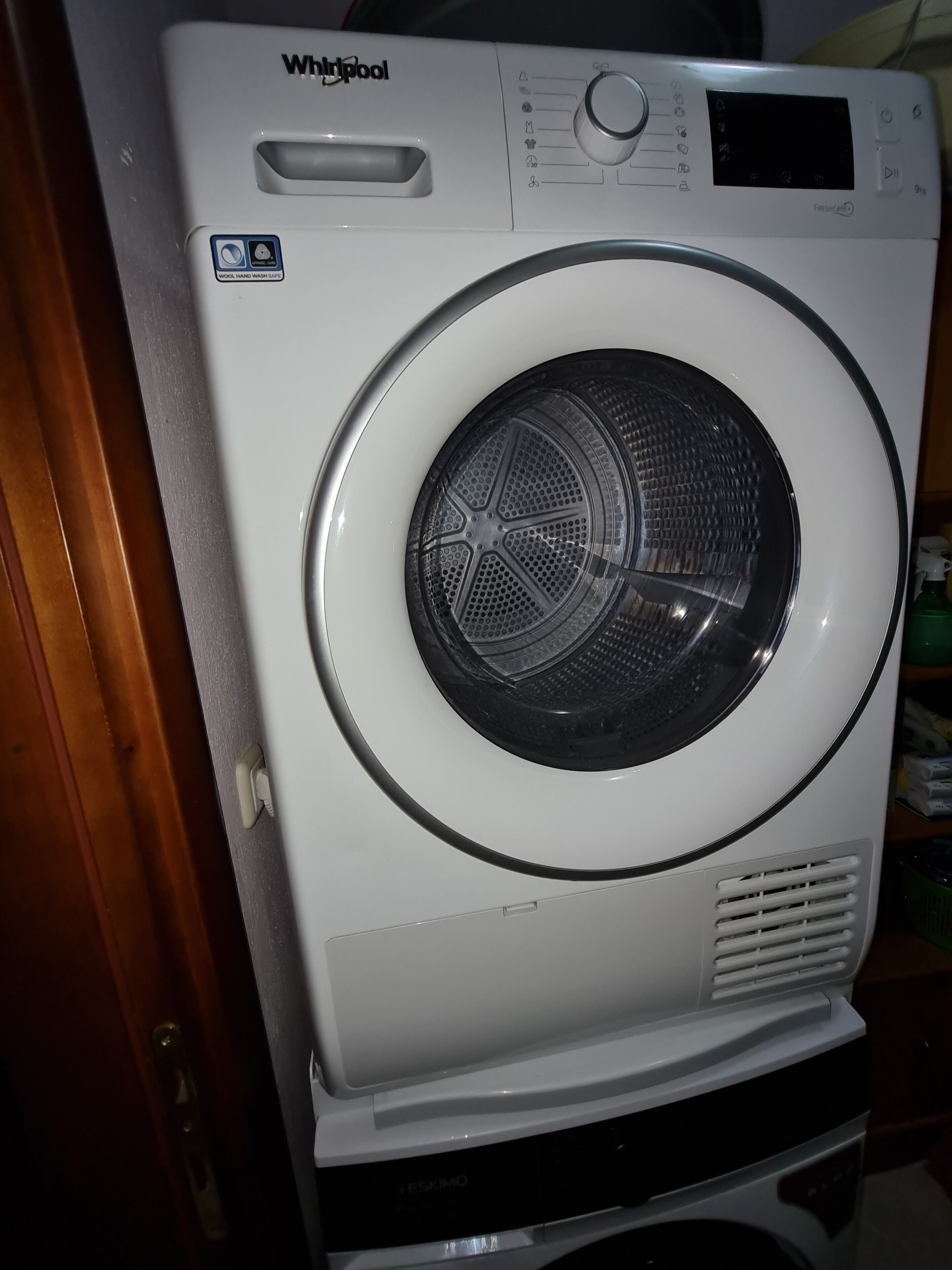 A front-loading Whirlpool washer with a control panel and a digital display.