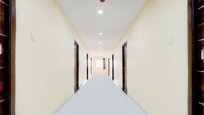 Un long couloir étroit, avec des portes de chaque côté, menant à différentes pièces.