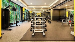 Ein Fitnessstudio mit unterschiedlichen Trainingsgeräten, großen Fenstern und modernem Design.