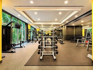 Ein Fitnessstudio mit unterschiedlichen Trainingsgeräten, großen Fenstern und modernem Design.