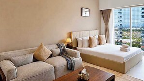 Ein modernes Wohnzimmer mit einer Couch, einem Couchtisch und einem großen Bett mit Blick auf Gebäude.