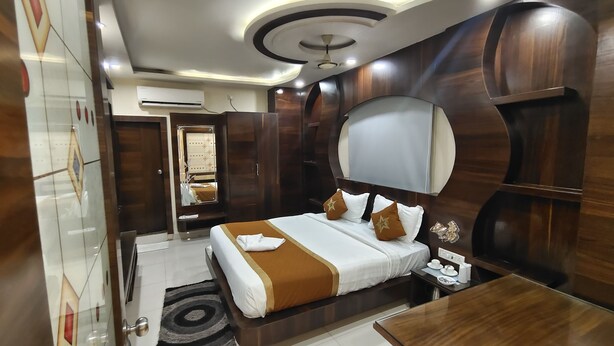 Habitación de hotel moderna con una cama grande, una mesita de noche, un espejo y un ventilador de techo.