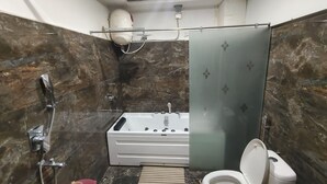 Un baño con bañera, inodoro y zona de ducha.