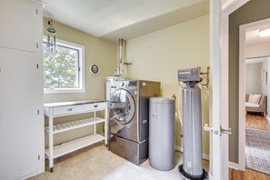 Ein Waschraum mit Waschmaschine, Trockner und Warmwasserbereiter.