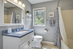 A bathroom with a sink, toilet, and shower curtain. - Updated Home Minutes to Downtown and Beach! (Sister Bay)