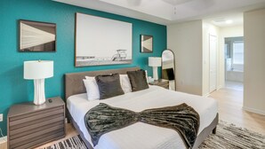 Una camera da letto con un letto, comodini, una ventola a soffitto e opere d'arte alle pareti.