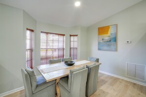 A dining room with a wooden table, grey upholstered chairs, and a large painting on the wall. - 4 Mi to River & Gardens! Quiet Port St Lucie Home (Port St. Lucie)