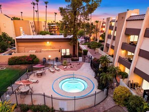 A hotel courtyard with a swimming pool, outdoor seating, and a fenced patio area. - Resort Pool + Spa + Balcony | Fashion Square + Echo Canyon | Camelback Cabana (Scottsdale)
