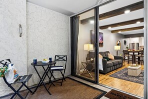 Ein modernes Interieur mit Essbereich, einer Couch und einer durch eine Glastür sichtbaren Küche.