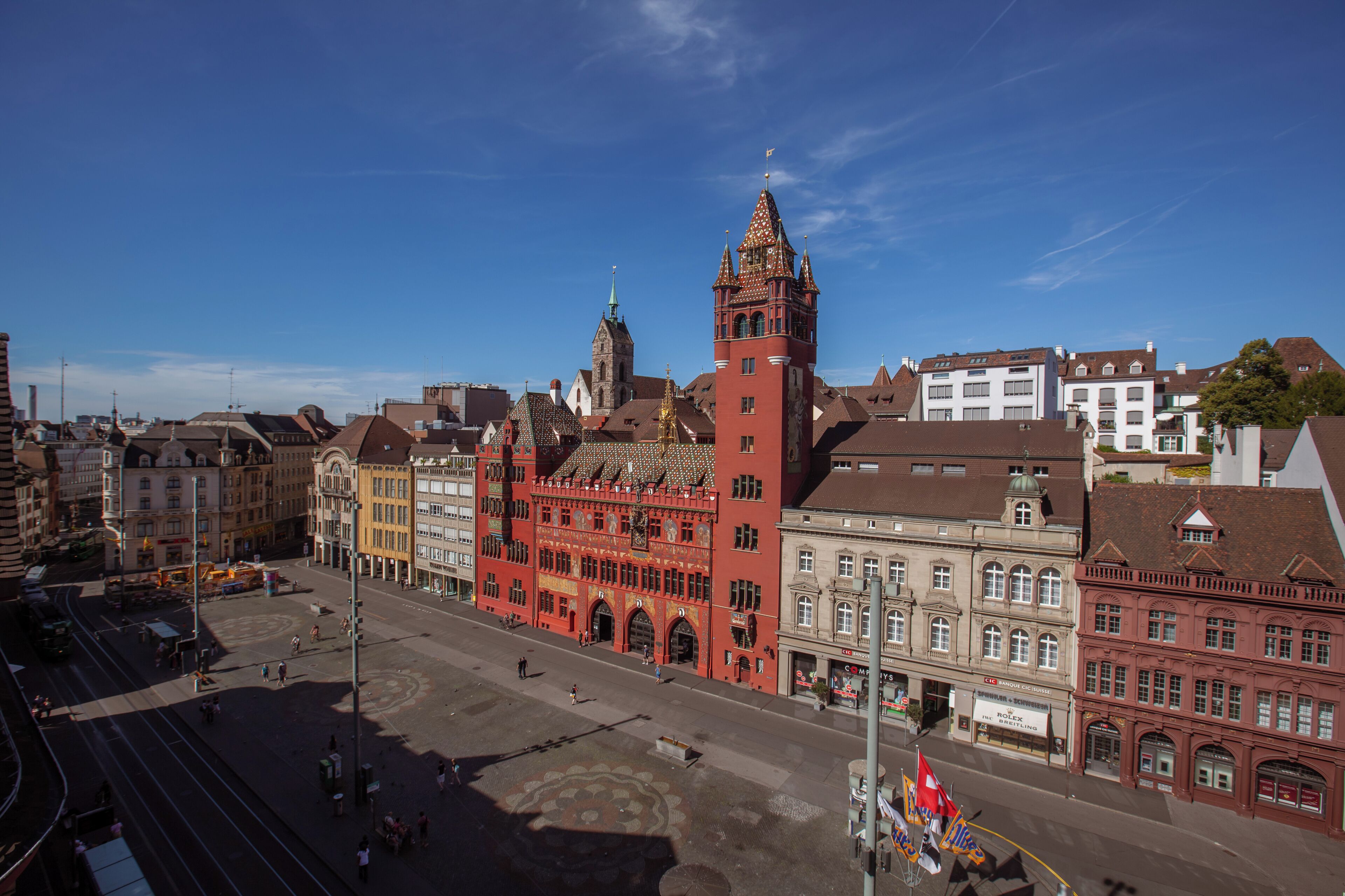 Ein historisches Gebäude mit einem markanten Turm und einem großen, offenen Platz davor.