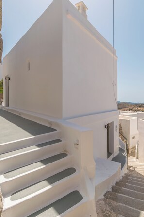 A white building with a staircase leading to a flat roof. - Astraea Traditional House in Milos Island (Trypiti)