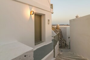 A narrow stairway leading to a door with a light fixture above it. - Astraea Traditional House in Milos Island (Trypiti)