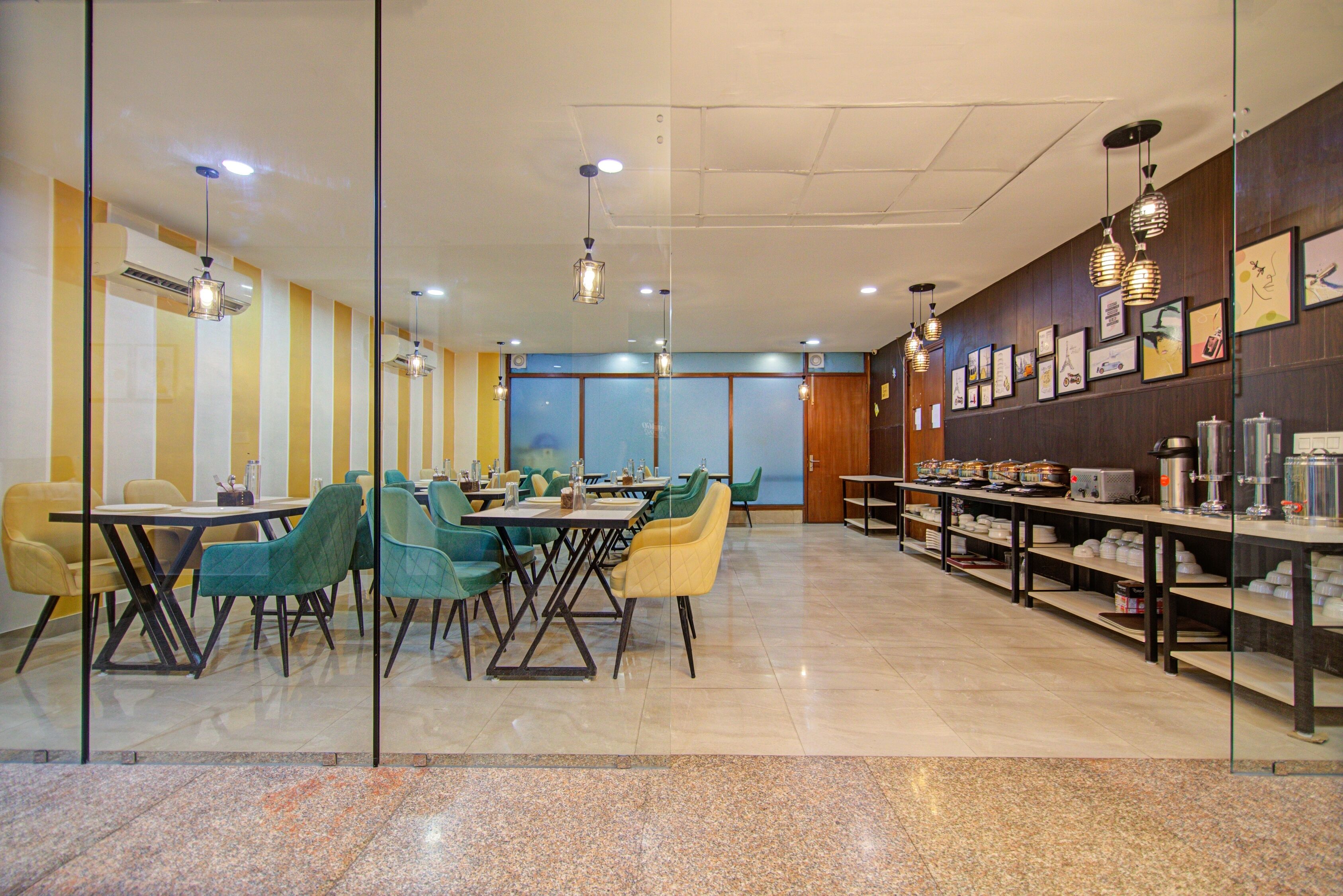 Een moderne eetruimte met tafels, stoelen, een buffet en kunstwerken aan de muur.