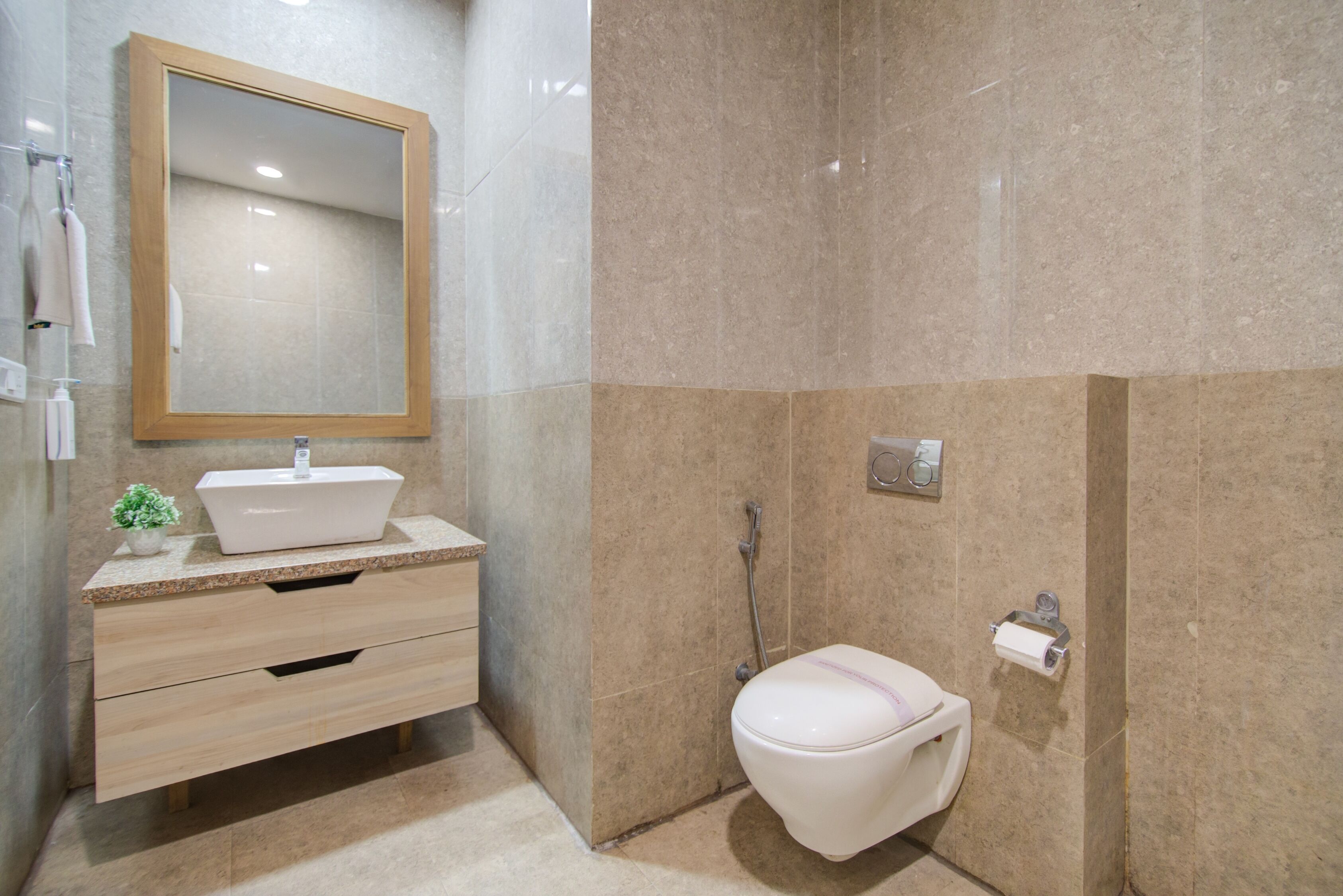 A modern bathroom with a vanity, sink, mirror, toilet, and shower.