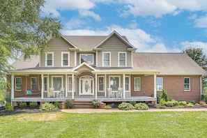 A two-story house with a front porch, brick facade, and a symmetrical design. - Day Trip to Nashville! Large Home on 5 Acres (Springfield)
