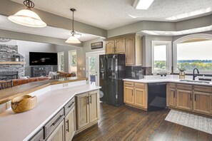 Una cocina moderna con una isla grande, armarios de madera y un refrigerador empotrado.