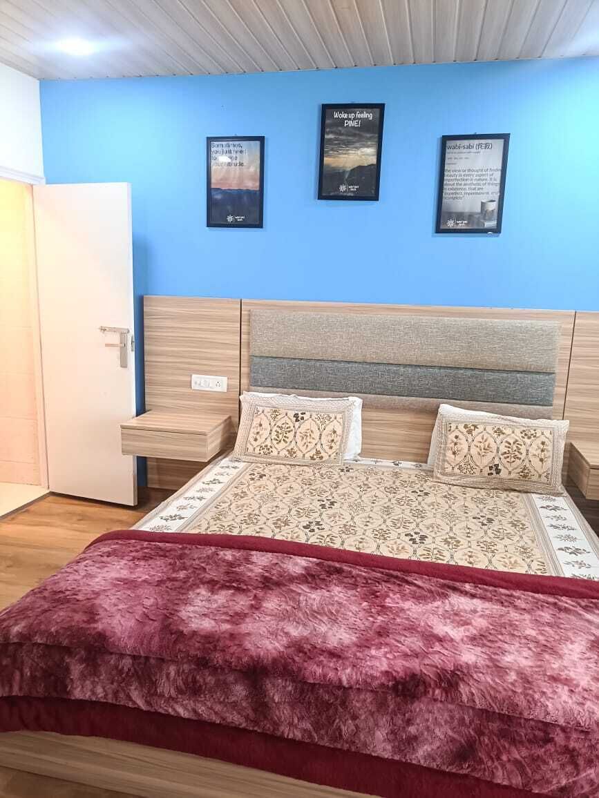 A bedroom with a bed, nightstands, a wardrobe, and wall art.