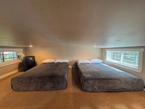 A room with two beds, a heater, and a window. - The Green Room, Music-Themed Tiny Home Near Lake Travis (Austin)