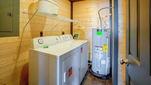 A laundry room with a front-loading washer and dryer, a drying rack, and a water heater. - Walk to the Water! Kentucky Lake Cabin (Murray)