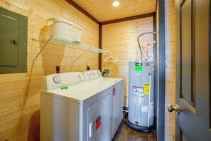 A laundry room with a front-loading washer and dryer, a drying rack, and a water heater. - Walk to the Water! Kentucky Lake Cabin (Murray)