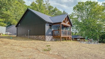 A large barn with a wooden deck and a metal roof.