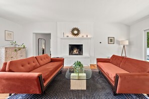 Un salon avec deux canapés, une cheminée et une table basse.