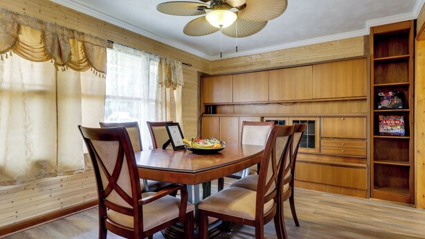 A dining area with a wooden table, chairs, and a ceiling fan. - Waterfront Family Home w/ Dock in Poquoson! (Poquoson)