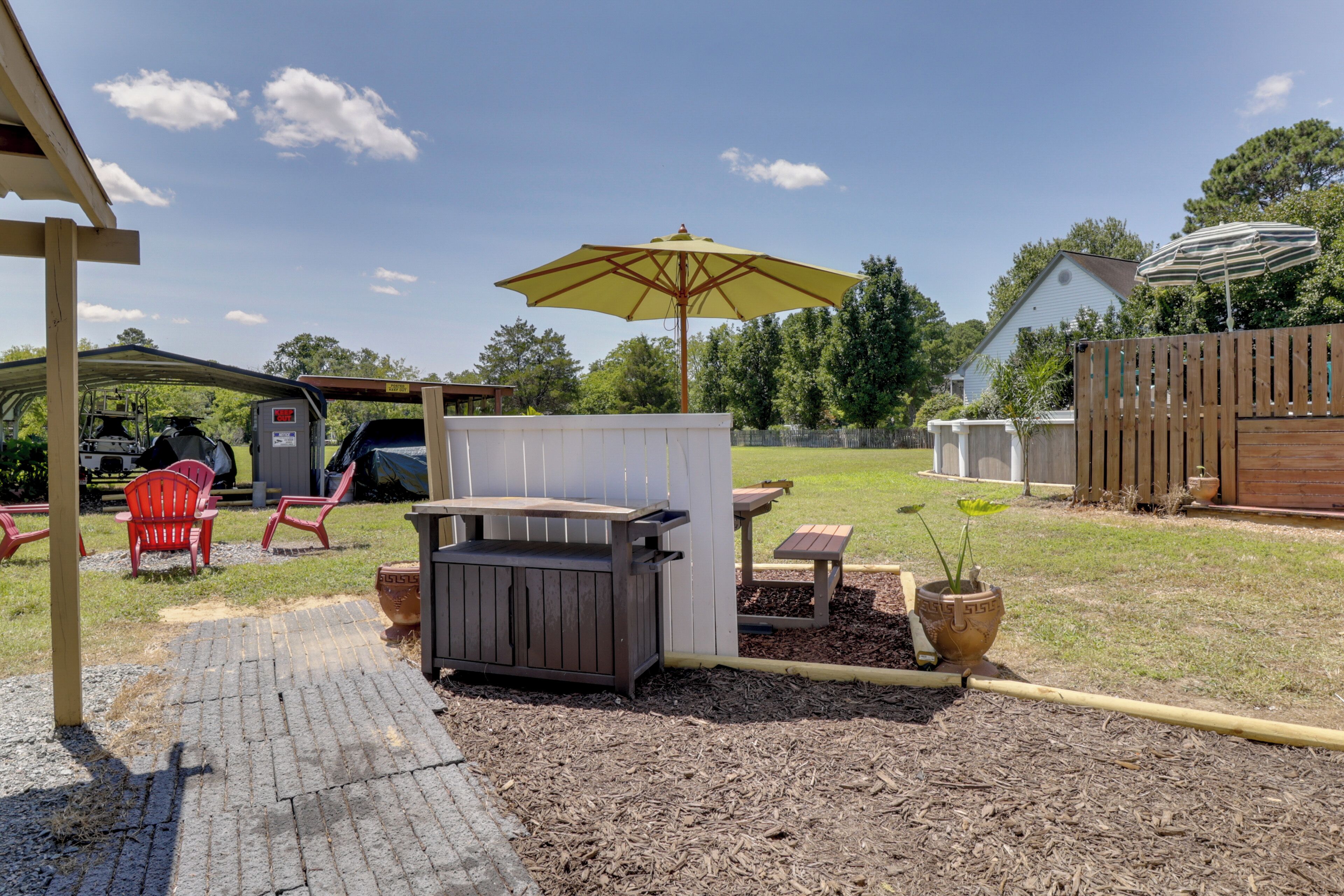 Patio trasero con una parrilla, mesa de picnic y zona de estar al aire libre.