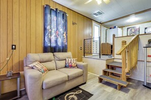 Ein gemütlicher Wohnbereich mit einer Couch, einem Couchtisch und einer Treppe zu einer oberen Ebene.