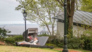 Uma área de jardim com mesas ao ar livre e vista para a água.
