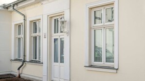 A building with three windows, a door, and a lamp post. - Villa Westfalia, Apartment 04, just 150 m from the beach, with a terrace - Cozy vacation rental in (Heringsdorf)