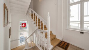 A staircase with white balusters and wooden steps, leading to a landing with a doormat and a window with a view. - Villa Westfalia, Apartment 04, just 150 m from the beach, with a terrace - Cozy vacation rental in (Heringsdorf)