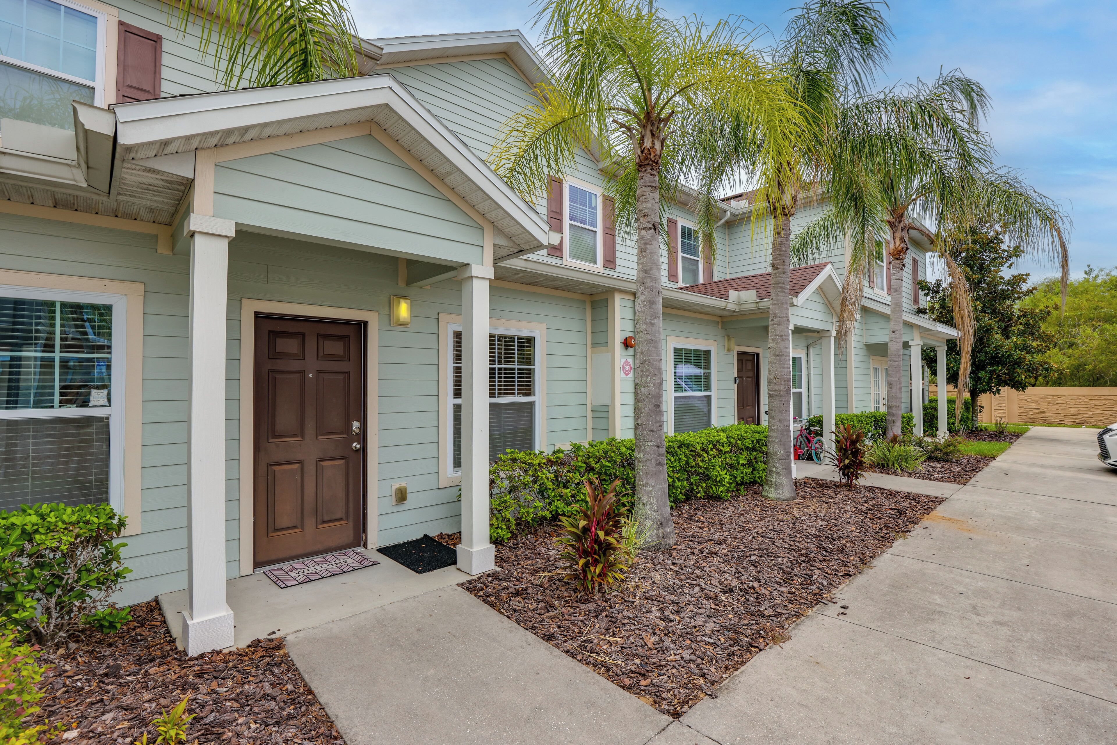A row of single-story houses with front porches and a sidewalk.
