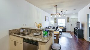 Uma cozinha moderna com bancadas de granito, eletrodomésticos de aço inoxidável e lava-louças.